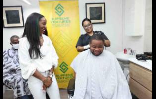 Gabrielle Waite (left), sponsorship and events coordinator, Supreme Ventures Limited, jokes with Rohan Burrell, assistant manager of St Augustine’s Place of Safety, as he gets his ‘Supreme Father’ treat courtesy of the Supreme Ventures Foundation.
    

