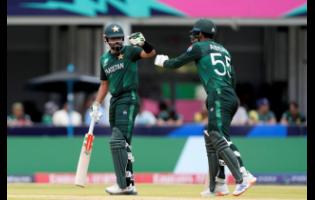Pakistan’s Abbas Afridi (right) moves to touch gloves with captain Babar Azam as they bat during an ICC Men’s T20 World Cup cricket match against Ireland and Pakistan at the Central Broward Regional Park Stadium in Lauderhill, Florida, yesterday.