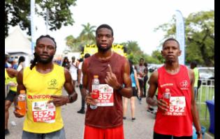  Winner Noel-Jonathan Ellis (centre) with second-place  Kemar Leslie (left) and  third-place Jomo-Rhys Gilman at the finish line of the Everyone’s a Winner 3K and 5K Run on Sunday, June 16 at the Hope Botanical Gardens. 