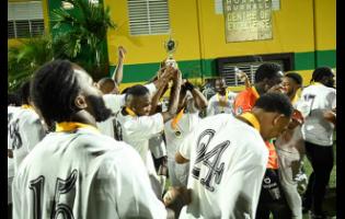 Chapelton Maroons celebrate  with the championship trophy after their win over Racers United in the Jamaica Football Championships (Tier II) final at the UWI-JFF Captain Horace Burrell Centre Of Excellence last night.