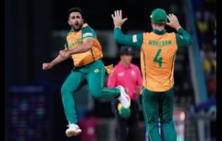 South Africa’s Tabraiz Shamsi (left) celebrates with teammate Aiden Markram after taking the wicket of West Indies’ Sherfane Rutherford during the ICC Men’s T20 World Cup cricket match between the West Indies and South Africa at Sir Vivian Richards Stadium in North Sound, Antigua and Barbuda last night.