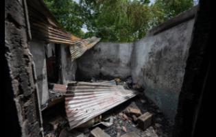 A section of one of four houses that was gutted during a fire early Thursday, which is believed to be have been set by gunmen.