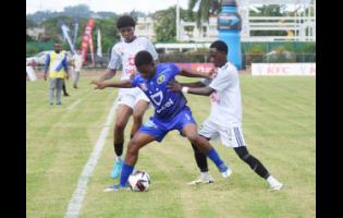 Waterford High’s Yashmaru Hanson (centre) is trapped between Mona High’s Sean Leighton (left) and  Savi-K Morton during the opening match of the ISSA/WATA Manning Cup football competition at Montego Bay Sports Complex on Saturday. Mona High won 7-0.