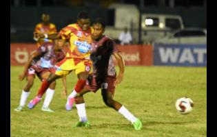 Cornwall College’s Miguel Arnold (second right) tries to claim possession before Herbert Morrison Technical’s Ranaldo Blackwood (right) during the opening match of ISSA/WATA daCosta Cup football competition at Montego Bay Sports Complex on Saturday. Cornwall College won 4-1.