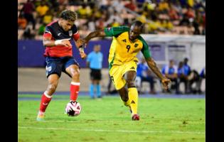 Jamaica’s Michail Antonio and Cuba’s Karel Perez (left) battle for possession during the Group B, Concacaf Nations League League A football match at the National Stadium on Friday. The game ended 0-0.