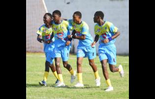 Penwood High School players embrace Jason Keyes (second left) after he scored against Kingston College during their drawn ISSA/WATA Manning Cup football match at Maverley playing field yesterday. The game ended 2-2.