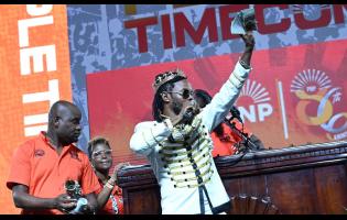 L.A. Lewis makes a donation to the People’s National Party at its 86th Conference, held at the National Arena in Kingston yesterday.