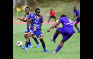 Cumberland High School’s Kalque Rose (centre) attempts to block the shot from Kingston College’s Demario Daley (right), during the ISSA/WATA Manning Cup football match at Stadium East on Saturday. KC won 18-0.