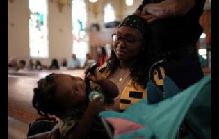 Parishioner Rose Carmelle Bellevue looks at her one-year-old son during a service at St Raphael Catholic Church in Springfield, Ohio.