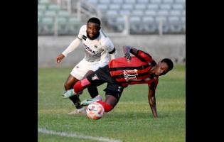 File photo shows Arnett Gardens’ Warner Brown falling after a tackle from Cavalier Soccer Club defender Gadail Irving during a Jamaica Premier League football match at Sabina Park on Sunday, January 7, 2023. Brown scored a double on Sunday in Arnett’s 3-0 win over Dunbeholden. 