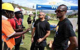 Dancehall artiste Sean Paul (second right) and Chef Brian Lumley (right) engage with community organisers in Beeston Spring, Westmoreland, during ongoing relief efforts for victims of Hurricane Melissa.