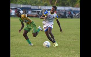 St Elizabeth Technical High School’s Kaieem Lewis (right) tries to outrun  Ocho Rios High’s Kawayne McInnis during their ISSA daCosta Cup round-of-16 football match at Drax Hall Sports Complex on Tuesday.