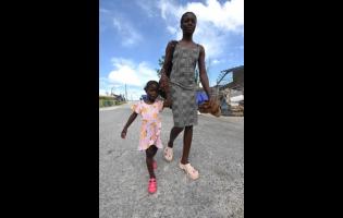 Nadine Samuels walks hand-in-hand with her daughter, three-year-old Gabrielle Dixon, through the streets of Lewisville, St Elizabeth.