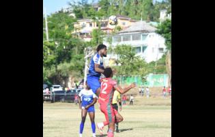 Mount Pleasant Football Academy’s Raheem Edwards (centre) jumps to head the ball while being challenged by Montego Bay United’s Timar Lewis (right) during their Jamaica Premier League football game at Jarrett Park on Sunday.