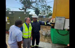 JPS President & CEO Hugh Grant (right) explains the operation of the new JPS Emergency Mobile Power Generation Unit to Minister of Energy Daryl Vaz (centre) and Floyd Green, member of parliament for St Elizabeth South Western. The mobile unit will power several communities including Treasure Beach and Calabash Bay.