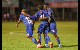 Three members of the Spanish Town Police FC team - (from left) Lamar Davis, Jordan Elliston and Shamar Harris - celebrate after they scored a goal against Waterhouse FC during their Jamaica Premier League match  at the Anthony Spaulding Sports Complex  on December 15, 2025. Spanish Town Police won 2-1.