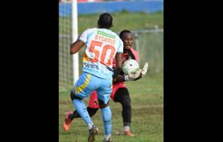 Racing United’s goalkeeper Aaron Enill catches the ball ahead of Waterhouse FC striker Atapharoy Bygrave during their Jamaica Premier League football match at Ferdi Neita Park on Sunday. The game ended 0-0.