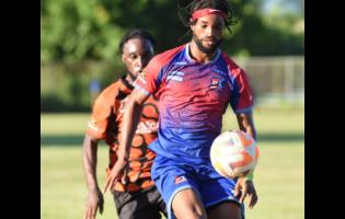 File photo shows Dunbeholden’s Chevoy Watkin (front) as he controls the ball under the watchful eyes of Tivoli Gardens FC’s Anthony Nelson during their Jamaica Premier League football match. Nelson was on target for Dunbeholden during their 4-0 rout of Treasure Beach FC..