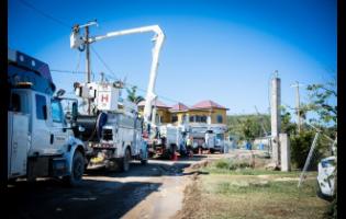 Credit: Contributed A row of JPS bucket trucks in Westmoreland signals active work on the power infrastructure leading to the National Water Commission’s Roaring River plant.