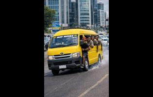 AI-generated image of a minibus speeding recklessly through a busy Corporate Area in Kingston, with passengers hanging out of the open doors.