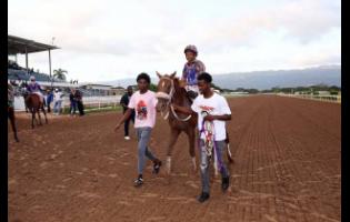 FERNANDO, with Raddesh Roman in the saddle, is led to the winners’ enclosure after winning The RIMSKY Trophy over six furlongs at Caymanas Park on Saturday.
