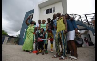 Credit: Ian Allen From the ashes of a seven-bedroom blaze two years ago, this family stands together today, keys in hand, in front of a brand-new home in Brooks Level, Stony Hill, St Andrew. The new dwelling promises hope and a fresh start.