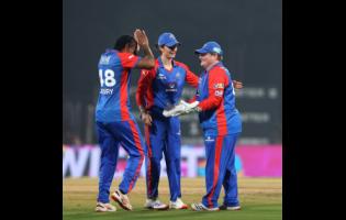 Credit: Courtesy of @WPLT20/IG Delhi Capitals’ Chinelle Henry (left) and wicketkeeper Lizelle Lee (right) celebrate a wicket during a Women’s Premier League T20 cricket match against the Gujarat Giants at the Dr DY Patil Sports Academy on Sunday.