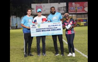 Jake Mahfood (left), commercial and  development manager of Wisynco, hands over his company’s $2 million cheque to Bruce Bicknell (second left), chairman of the Waterhouse FC, on Sunday at the Waterhouse Mini Stadium. Looking on are Chevon Lewis (second right), brand manager of MPOWER and Aundreen Leslie, social media officer of Waterhouse. 