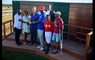 Winning connections of PACK PLAYS, including jockey Christopher Mamdeen (second right) at the presentation of the Eileen Cliggott Memorial Trophy, ran over six-and-a-half furlongs, at Caymanas Park on Saturday.