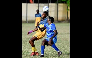 Racing United’s Shavaun Reid heads the ball in a challenge with Molynes United’s Dhumar McLaughlin during the Jamaica Premier League football encounter at Constant Spring playing field on Sunday. Racing United won 1-0.
