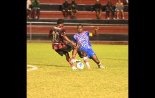 Rushike Kelson of Arnett Gardens FC (left) and Seigle Knight of Portmore United FC challenge for the ball during the Jamaica Premeir League football fixture at the Anthony Spaulding Sports Complex on Monday night. Portmore won 2-0.