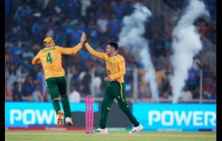 South Africa’s Keshav Maharaj (right) celebrates with captain Aiden Markram the wicket of India’s Arshdeep Singh during the T20 World Cup cricket match in Ahmedabad, India, on Sunday, Feb. 22, 2026.
