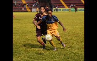 Mikyle Williams of Racing United FC (right) controls the ball as Marcos Filho of Chapelton Maroon FC approaches during the Jamaica Premier League football match at the Anthony Spaulding Sports Complex in Kingston yesterday. Racing were 2-0 winners.