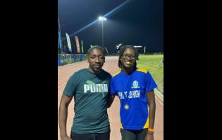 Coach Derol Gardener (left) of Penwood High with his athlete Shakeya Reid minutes after she won silver in the Class One 100 metres at the recent Corporate Area Championships. 