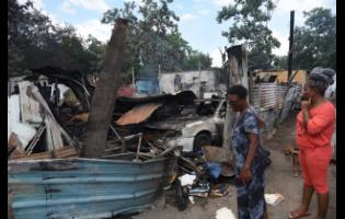 Passers-by look at what is left of the homes.