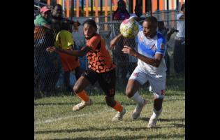 Joshua Dewar (left) of Tivoli Gardens FC and Odean Pennycooke of Dunbeholden FC compete for the ball during the Jamaica Premier League football competition at the Edward Seaga Sports Complex on Sunday.