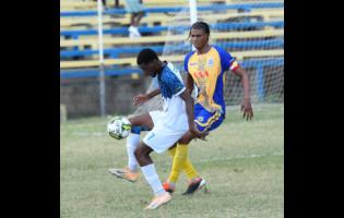 Tajay Grant (left) of Racing United FC controls the ball as Garth Stewart of Harbour View FC approaches him during the Jamaica Premier League Football match at  Harbour View Mini Stadium in Kingston on Monday. 