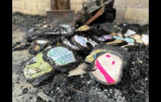 Burnt children’s books are left in the ashes after the home of a family of seven was destroyed in a fire which took the life of six-month-old Nyermah Graham in Guinep Lane, Montpellier, St James on Tuesday.