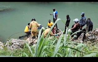 The body of 17-year-old Oshene Darby is taken from the Rio Cobre in the Bog Walk Gorge on Tuesday, after the vehicle he was reportedly driving plunged into the river on Monday night.