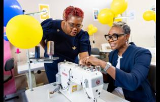 State Minister in the Ministry of National Security and Peace, Hon Juliet Cuthbert-Flynn (right), is being assisted by Chief Technical Director in the Ministry, Shauna Trowers, with threading a sewing machine in the new sewing lab at the South Camp Juvenile Correctional and Remand Centre in Kingston, at the official opening of the facility recently.

