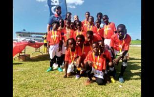 Insports’ Officer Sylvester Campbell (back row, left) shares the celebratory moment with Insports Trelawny Primary football champions Clark’s Town after the final at Trelawny Multipurpose Stadium earlier this week.