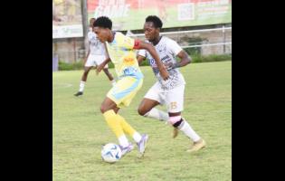 Credit: Ian Allen Ky-Mani Campbell of Waterhouse FC is pressured for the ball by Dwayne Allen (right) from Cavalier SC during the Jamaica Premier League football match at Drewsland Mini Stadium on Sunday.