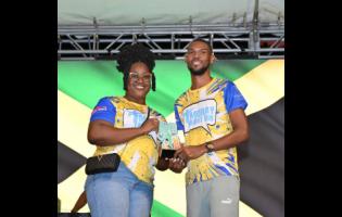 Credit: Ashley Anguin Amoy Gray (left), MoBay Night Run administrator, presents Garfield Gordon, UCT Steppas, winner of the male section of the 5K Run/Walk with his trophy at Harmony Beach Park in Montego Bay on Saturday night.