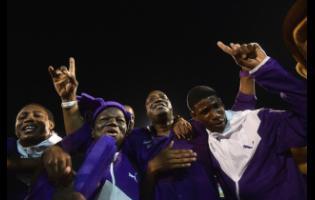 Kingston College Principal Dave Myrie (centre) celebrates with athletes after winning the 2019 Boys’ Championships.