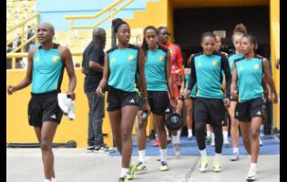 Members of the Reggae Girlz squad enter the National Stadium for a training session for their football game against Antigua & Barbuda on Friday.