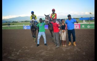 BARNABY (right), with champion Jockey Raddesh Roman in the saddle and stablemate NERO STAR, with Jahvaniel Patterson aboard, parade with connections after BARNABY won the Lloyd Linbergh “Lindy” Delapenha Memorial Trophy, ahead of NERO STAR over a mile at Caymanas Park on Sunday, February 8.