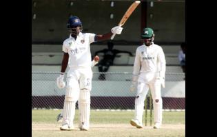 Barbados Pride’s Kevin Wickkham raises his bat after scoring 150 against Jamaica Scorpions on the opening day of their West Indies Championship cricket match against Jamaica at Chedwin Park in St Catherine on Sunday.