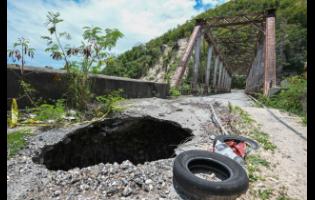 A gaping hole tears through the approach to the bridge in Easington, St Thomas.