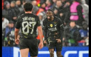 PSG’s Ousmane Dembele (right) celebrates after scoring his side’s opening goal during the Champions League quarterfinal second leg match between Liverpool and Paris Saint-Germain in Liverpool, England yesterday.