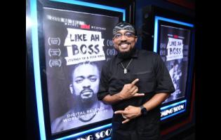 Machel Montano poses beside a poster for the documentary of his life ‘Like Ah Boss’. The project was premiered at the Carib cinema yesterday.